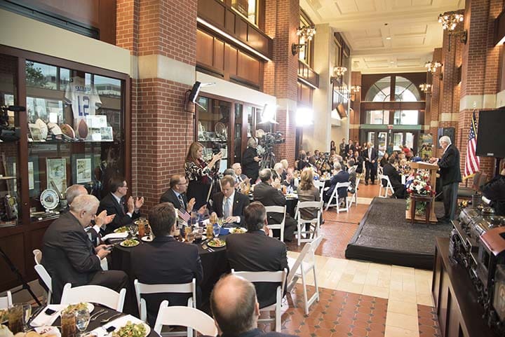 People dining in a spacious indoor restaurant with brick walls.