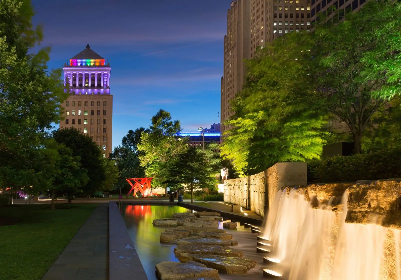 Cityscape with illuminated building and waterfall.